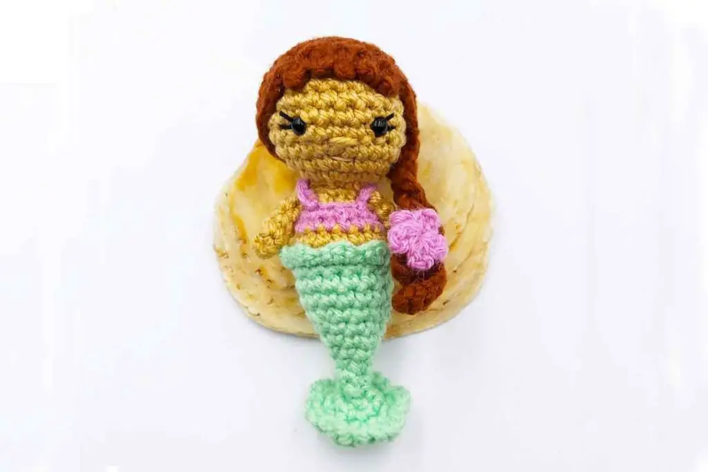 Small crochet mermaid with a flower in her braid