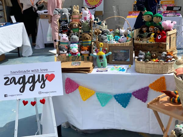 Craft fair display table with amigurumi toys and crochet bunting