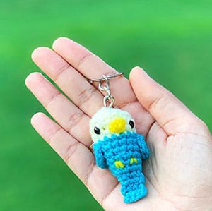 Small crochet bird keychain in a hand.