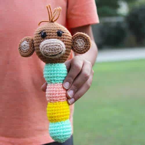 crochet monkey baby rattle being held by a child