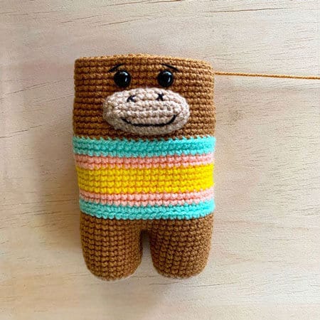 incomplete amigurumi monkey with eyes inserted and muzzle sewn on