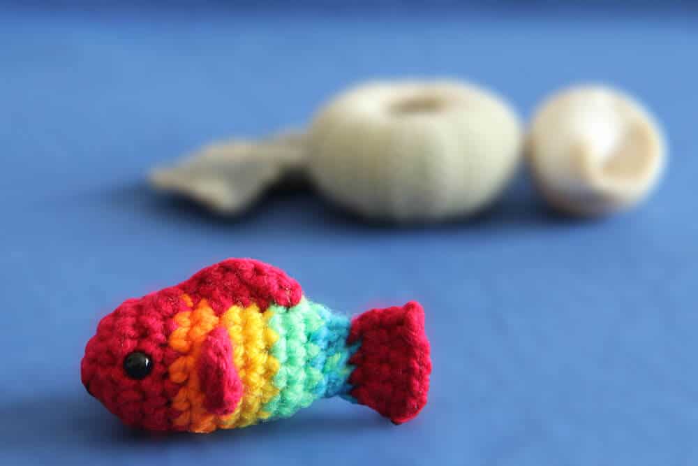 small crochet fish with shells in the background