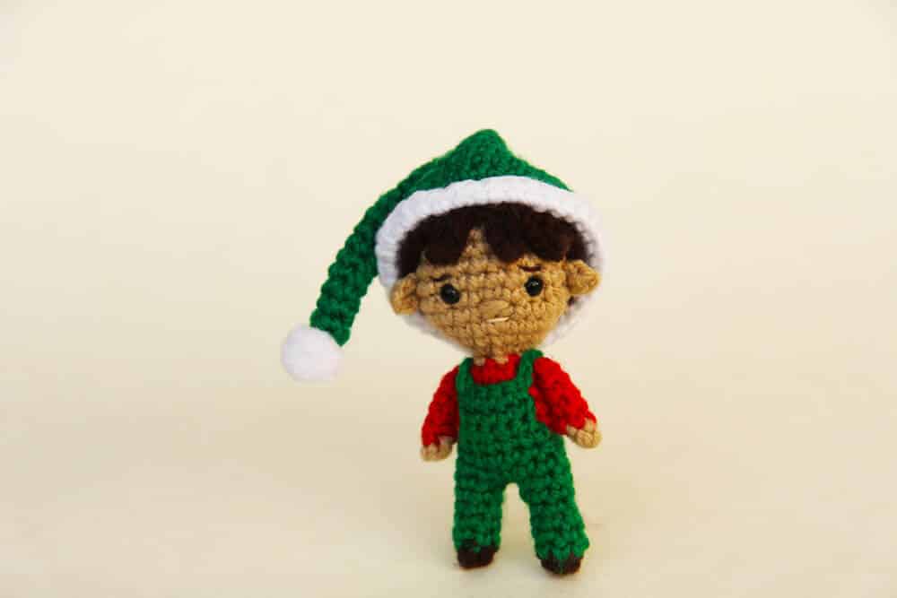 Christmas boy amigurumi elf with a green hat and crochet overalls