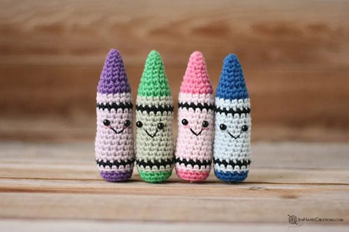 four one piece kwaii crayon amigurumi in purple green pink and blue