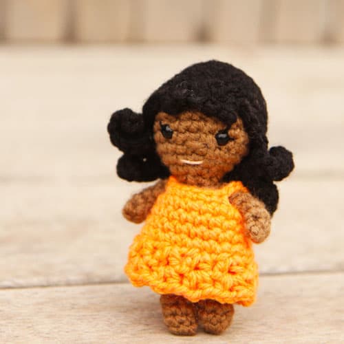 small crochet doll with wavy hair and a removable lacy dress
