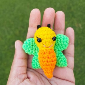 small crochet butterfly keychain in a hand