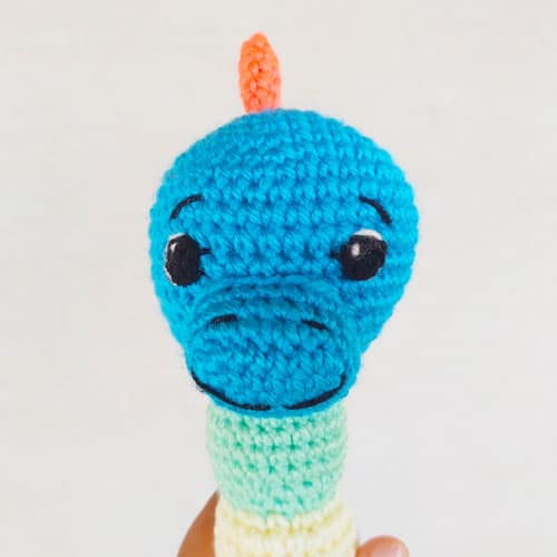 close up of the head of the dinosaur baby rattle