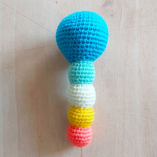 body of the dinosaur rattle with a blue head and a multicoloured stem
