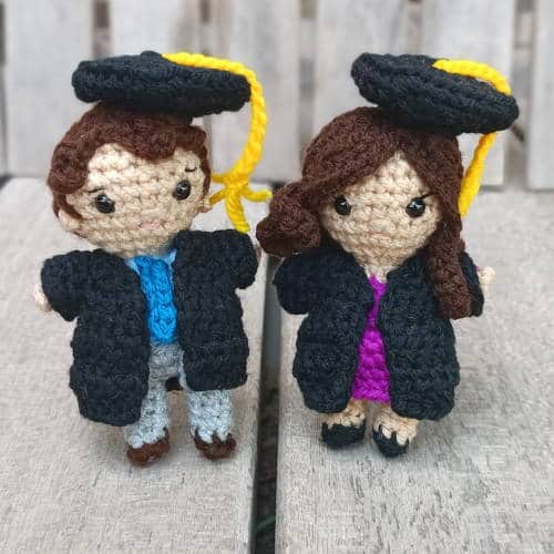 small boy and girl crochet dolls with graduation caps and gowns