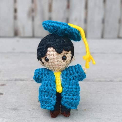 boy crochet graduation doll in a green cap and gown
