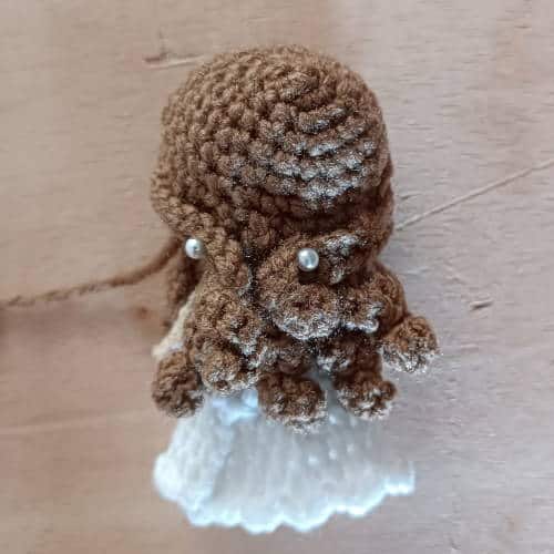 back of the crochet bride doll with the two front strands of hair pinned at the bottom