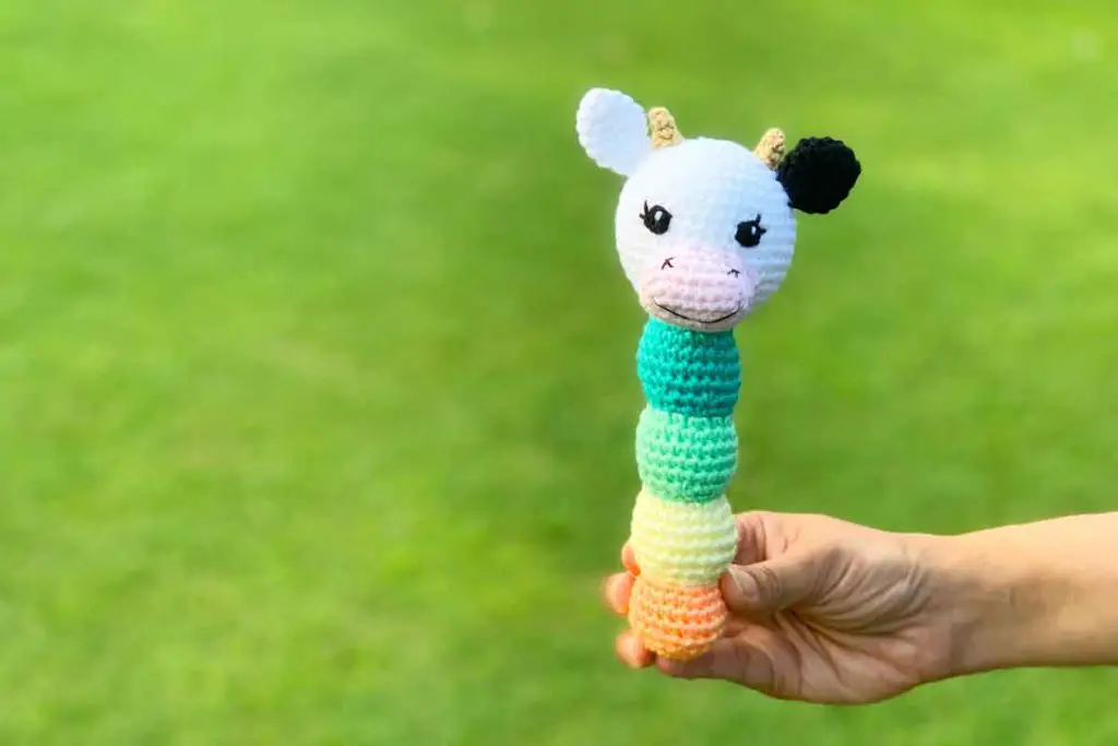 Cow crochet baby rattle with a colourful stem