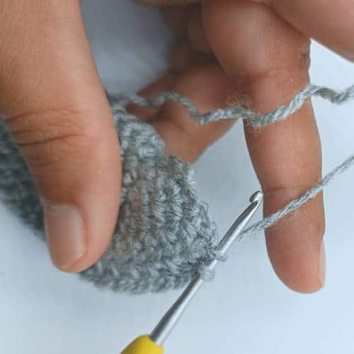 crochet hook inserted into the first stitch on the inside of the jacket