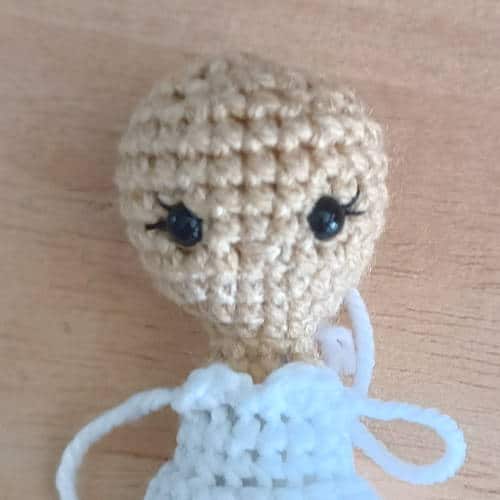 crochet doll with a white dress with a completed sweetheart neckline