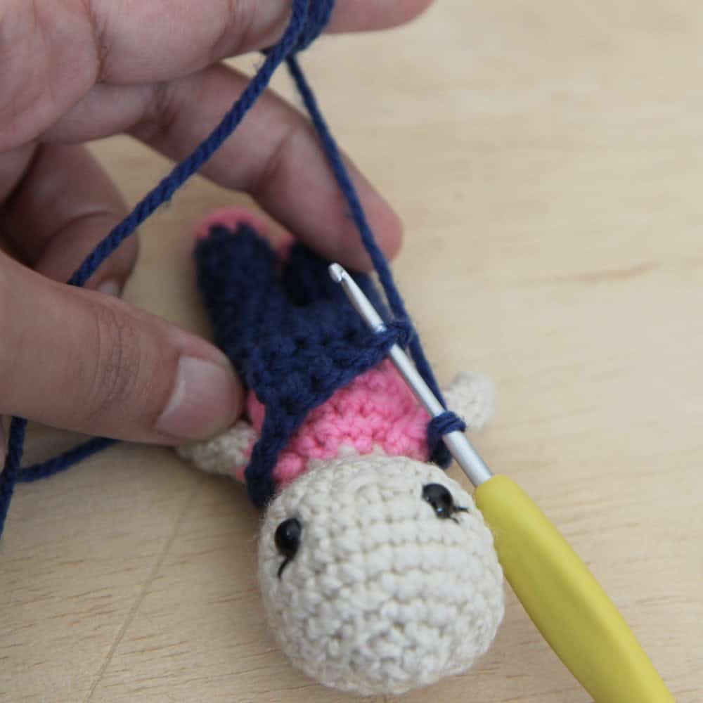 Crochet hook inserted into the overalls bib
